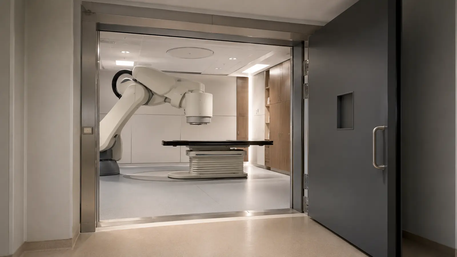 Behandlungsraum für CyberKnife mit Roboterarm in Parkstellung neben der leeren Liege