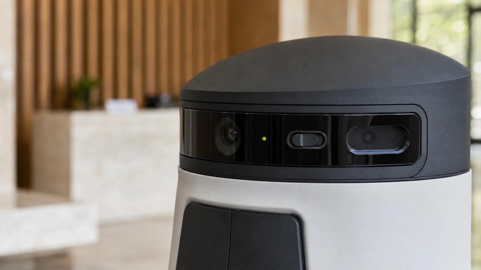 Nahaufnahme von Kamera und Sensorik am Kopf eines Empfangsroboters mit dezentem Lime-Statuspunkt