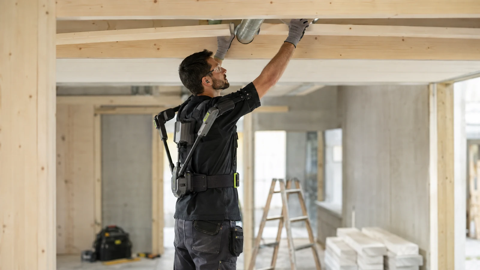 Handwerker auf einer Baustelle mit generischem Exoskelett bei körperlicher Arbeit.