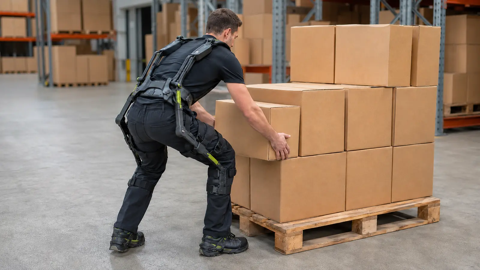 Lagerarbeiter mit passivem Rücken-Exoskelett hebt eine Kiste